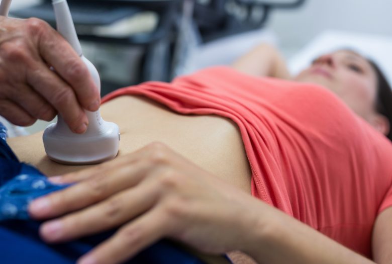 Woman getting ultrasound of a abdomen from doctor